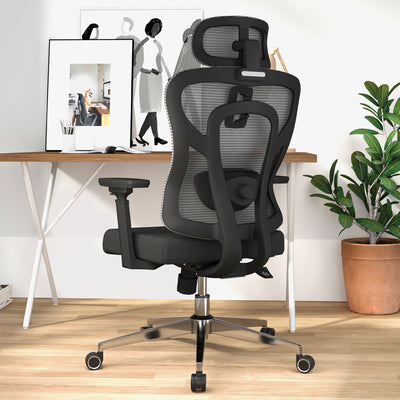 an image of a black ergonomic office chair with mesh back and a sponge cushion, with a standing desk and some books on the desk